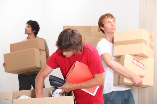 Moving crew handling desks and boxes in a Fulham office